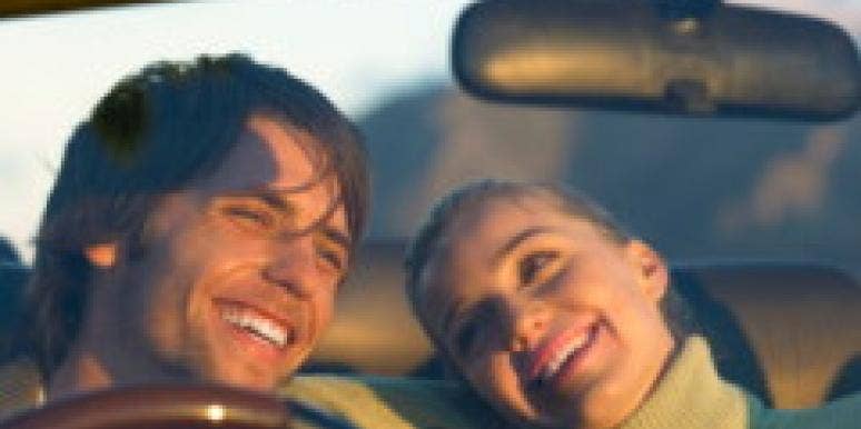 5 Male-Suggested Road Trip Must-Haves a couple laughing as they are driving in car