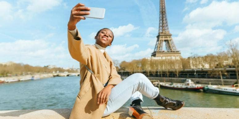 woman taking photo in front of Eiffel tower