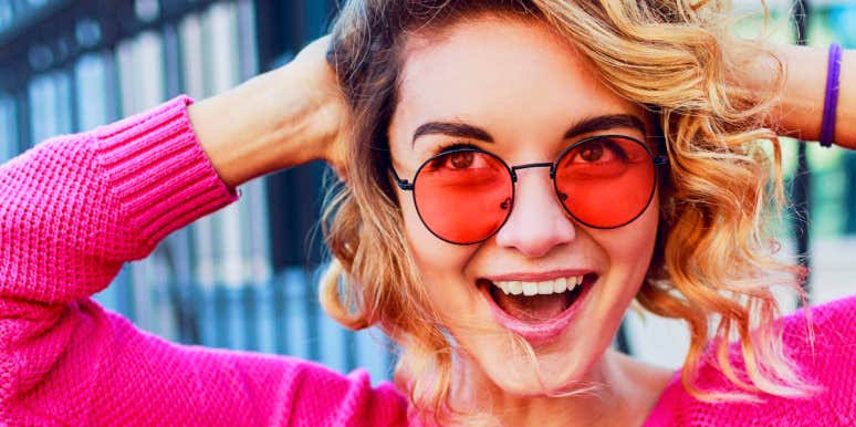 Self Confidence Free spirited woman in pink with funky shades smiles at camera