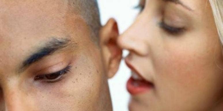 woman whispering in man's ear