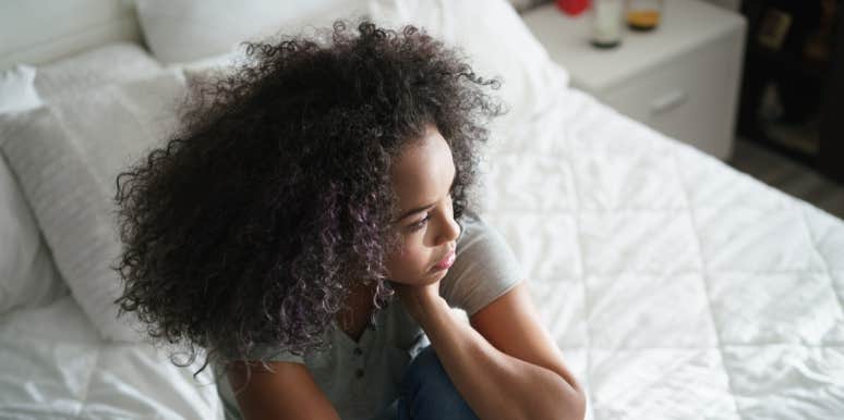 He Raped Me, But I Went Out With Him Again. Here's Why. woman on bed with hand on face