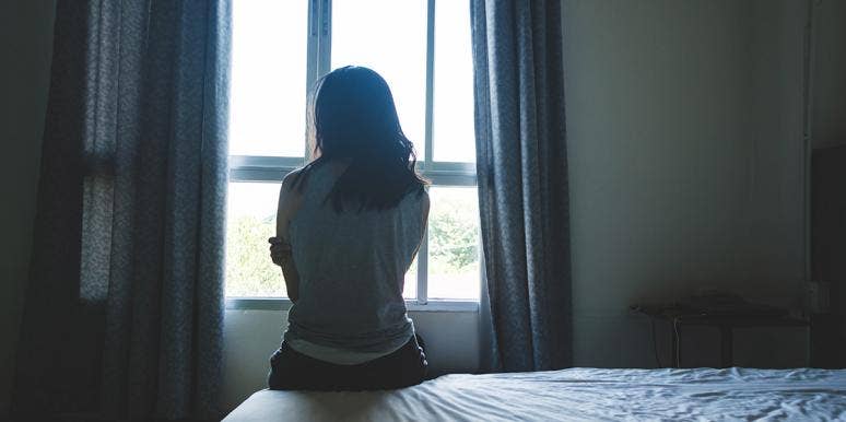 You Can Get PTSD From Staying In A Sexually Abusive Relationship woman in shadow looking out window