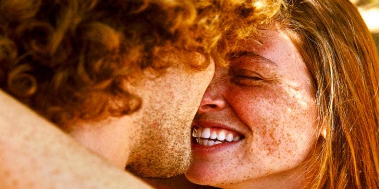 man and woman with freckles smiling kissing