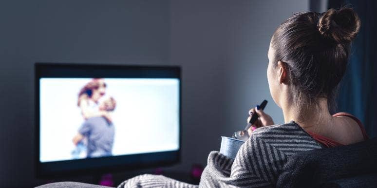 single forever woman watching couple on tv and eating ice cream
