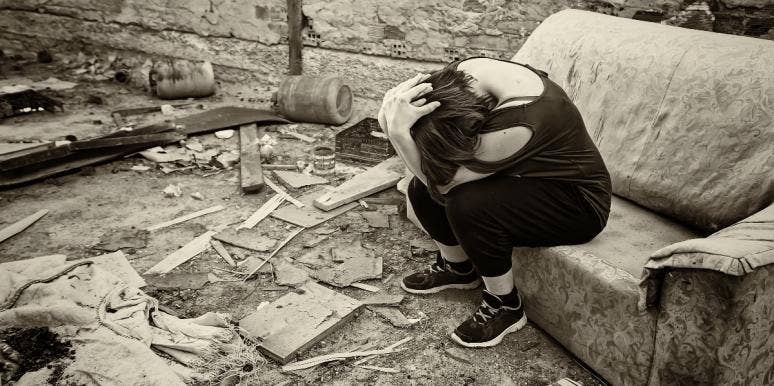 existential dread woman with head in hands in abandoned house