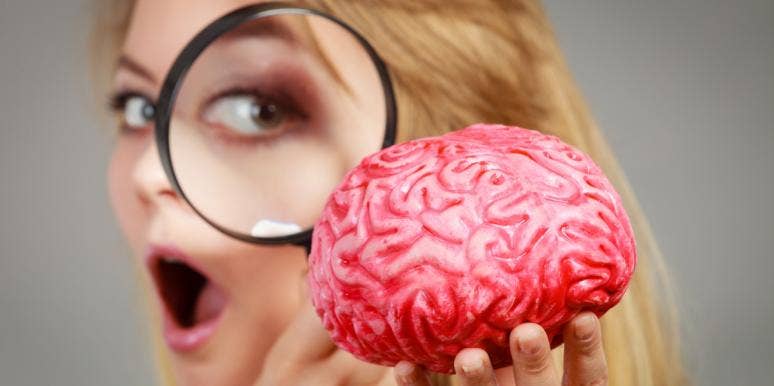 woman look at brain through magnifying glass