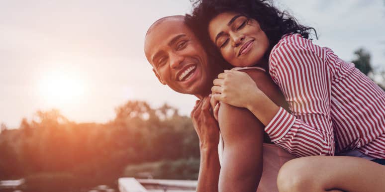27 Signs He's Husband Material, According To Experts woman hugging boyfriend who is husband material