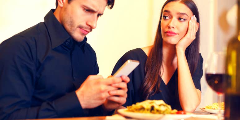 woman thinking about divorce while sitting next to her husband looking at his phone