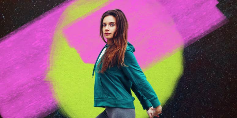 young woman in green hoodie in front of spacey background in pink and green
