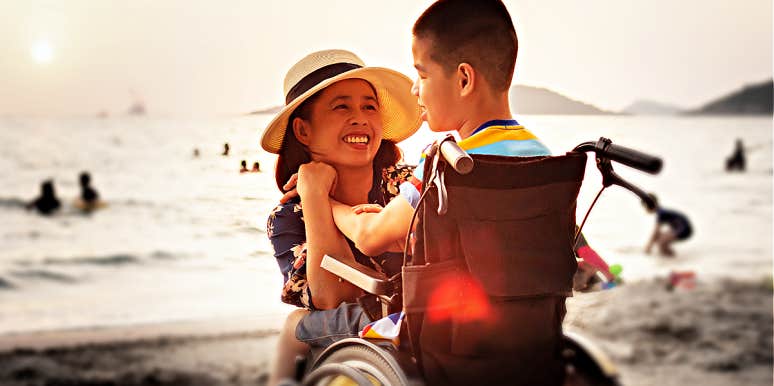 Why Parents Of Special Needs Kids Risk Silent Depression mom and son who uses wheelchair looking lovingly at one another on beach