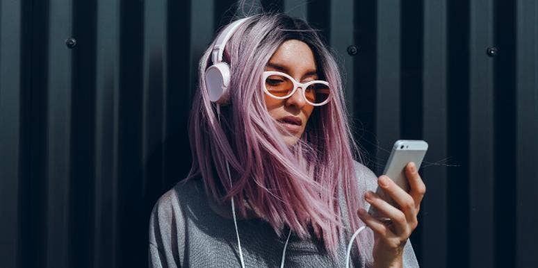 15 Songs About Deserving Better In A Relationship woman with purple hair listening to music on her phone