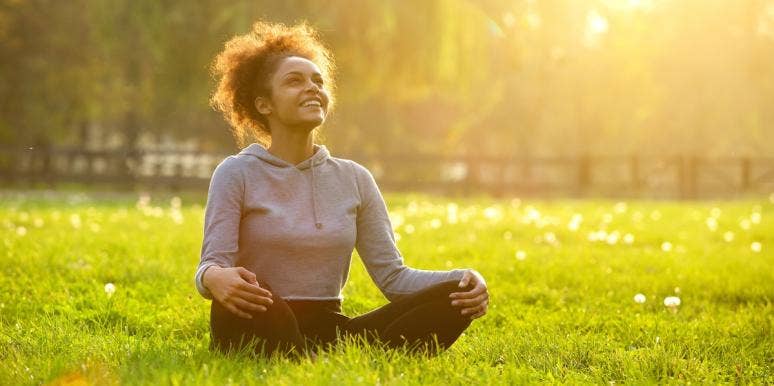 spiritual transformation woman sitting on the grass under the sun