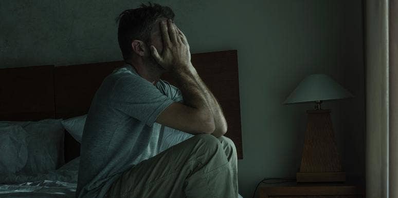 What It's Really Like To Be The Spouse Of A Sex Abuse Victim man with head in hands sitting in dark