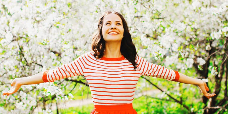 brunette woman smiles in spring blossoms