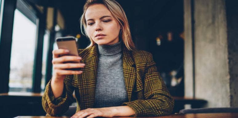 The Scientific Reason We Stalk Our Exes After A Breakup sad woman looking at phone