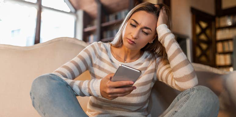 Study Says Women Suck At One Particular Aspect Of Online Dating woman looking at iphone with head in hand