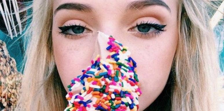 The One Question That Will Reveal If You're A Sugar Addict woman eating unhealthy food