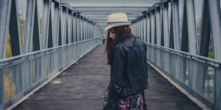 What 'Taking The High Road' Means & Why It Doesn't Always Work woman on a bridge walking away