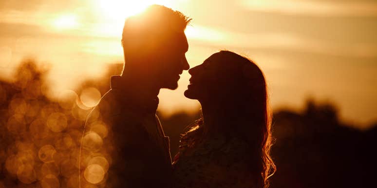 man and woman looking at each other in sunset