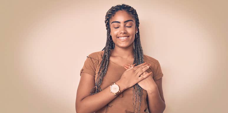 The Subtle-Yet-Obvious Reason You Don't Love Yourself — Yet woman holding hands by her heart