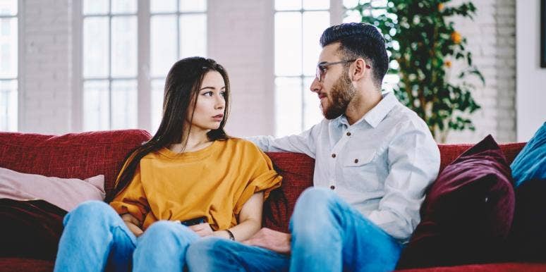 sad man and woman sitting on couch