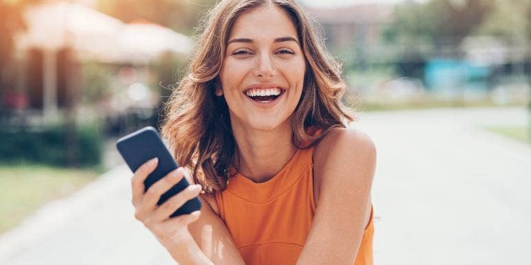 woman laughing holding her phone