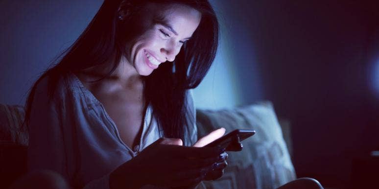 happy woman on her phone in the dark