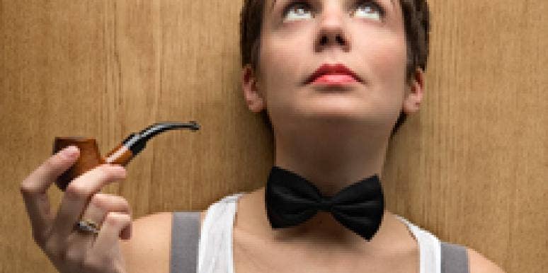 Steal These 7 Items From Your Guy's Closet woman wearing a bowtie looking up while holding a pipe