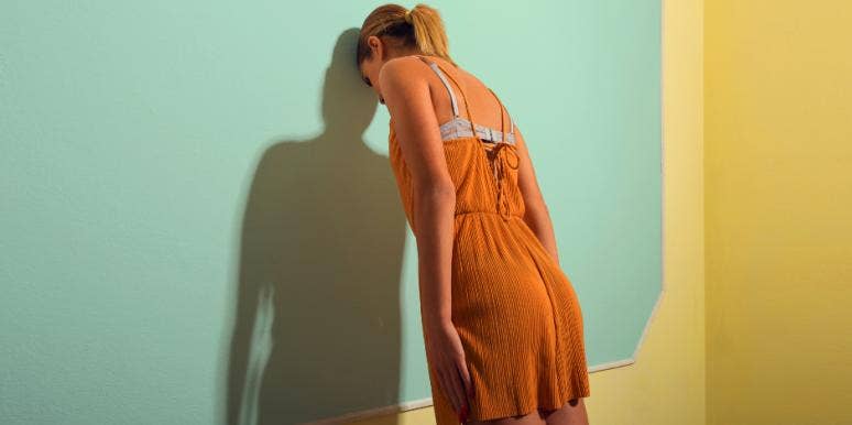 12 Sad Signs You're Emotionally Damaged & Are Too Broken To Love woman leaning her head against a wall