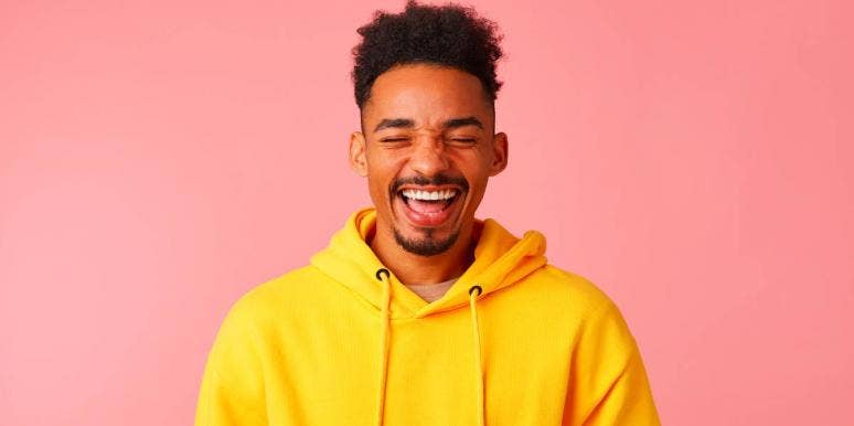 man in yellow hoodie smiling mouth open