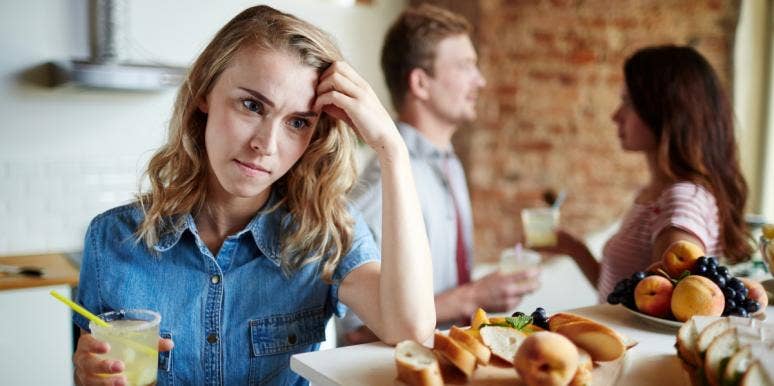 types of cheating woman looking upset while man and woman talk behind her