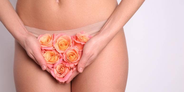 woman with dry flowers covering vagina
