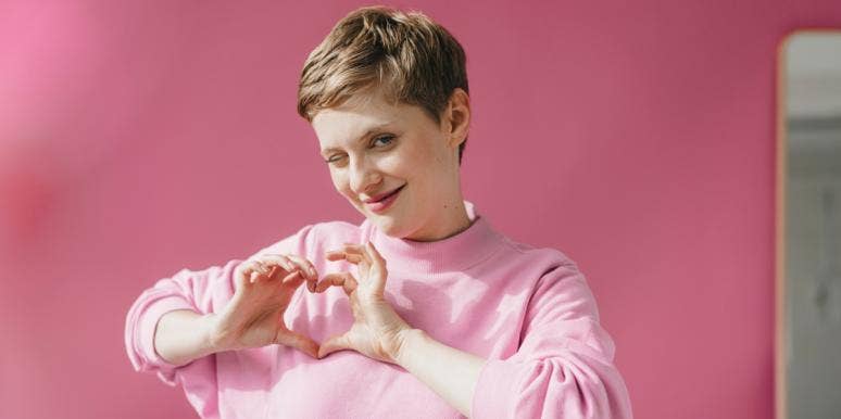 winking woman making a heart with her hands