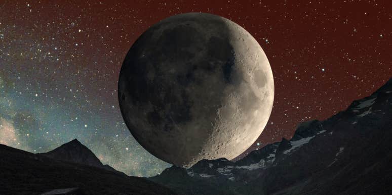 waxing crescent moon behind mountain range