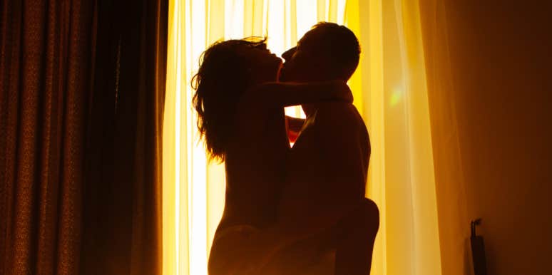 couple kissing in front of window