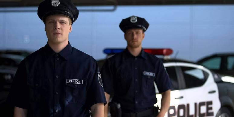 What Does ACAB Mean? History Of 'All Cops Are Bastards' two police offers standing in front of police car