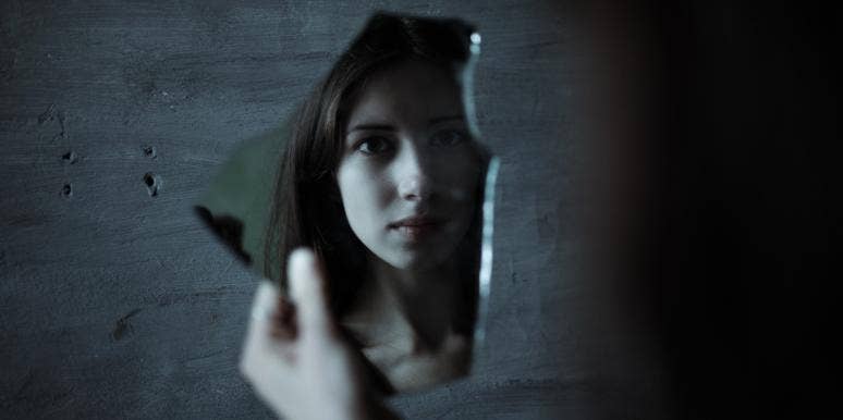 what does it mean to recognize your grief triggers woman looking at broken mirror shard
