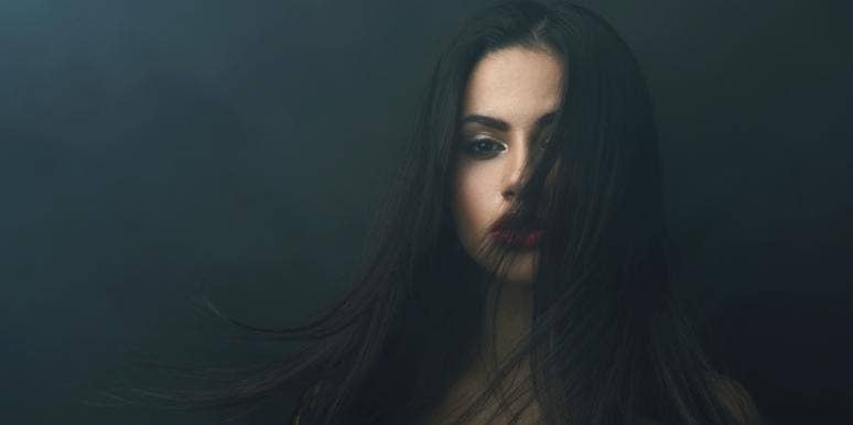 The Moment Society Taught Me What It Means To Be A Woman sad woman in the dark with hair covering face
