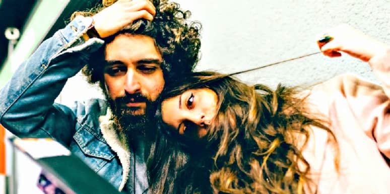 brunette couple, each with lots of curly brown hair, looks sad and serious