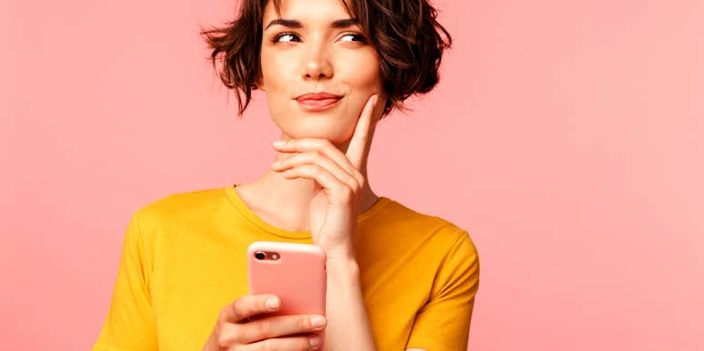 woman holding cellphone wondering what to say to a guy on Tinder