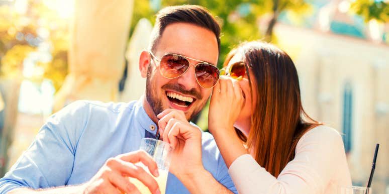 woman whispering emotional trigger phrases into a smiling man's ear