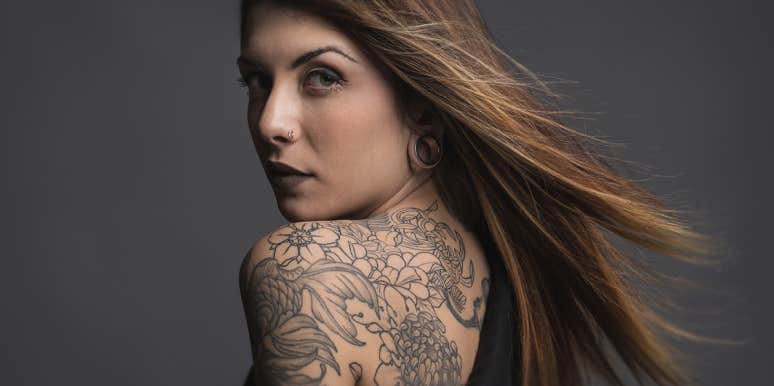 What Your Tattoo Placement Says About Your Personality woman with tattoo on shoulder looking back