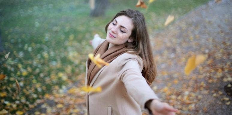 What's The Difference Between Equinox And Solstice? woman standing in leaves in the fall
