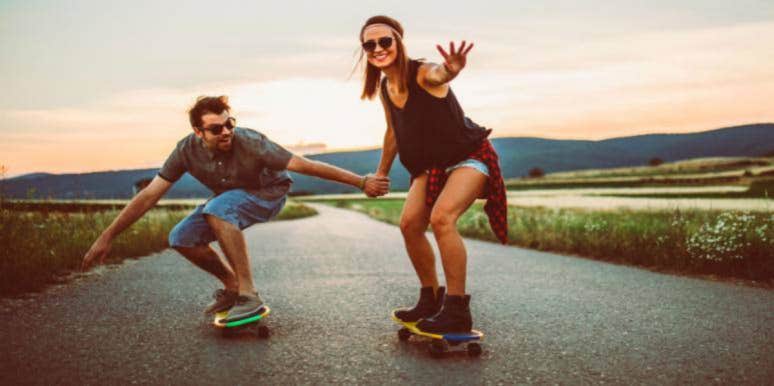 What It Means When A Guy Talks About Marriage And Babies Too Soon man and woman holding hands while skateboarding