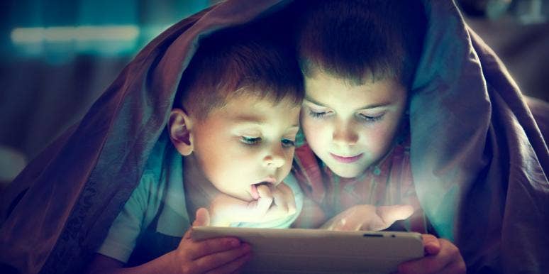 two boys under blanket in dark