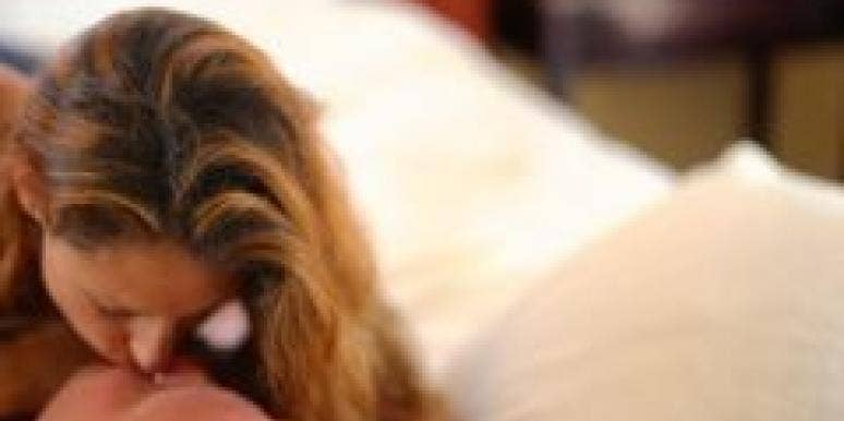 7 Ways To Set The Mood For Great Sex caucasian couple kissing in bed with bedroom out of focus