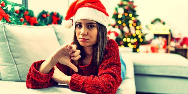 I Hate Christmas: 11 Reasons People Hate The Holidays woman with Santa hat on giving a thumbs down