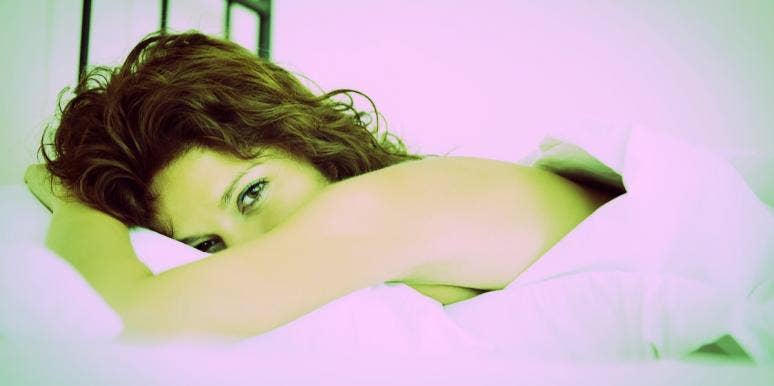 8 Reasons Lube Burns Or Stings Your Vagina (And What To Do) woman lying in bed while lube burns