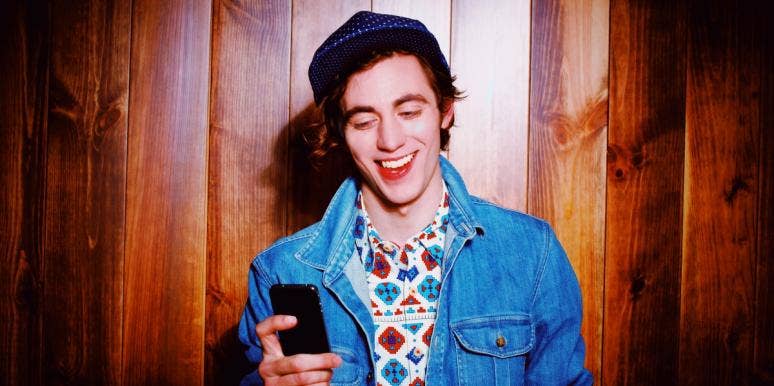 why men are not falling in love happy man looking at his phone