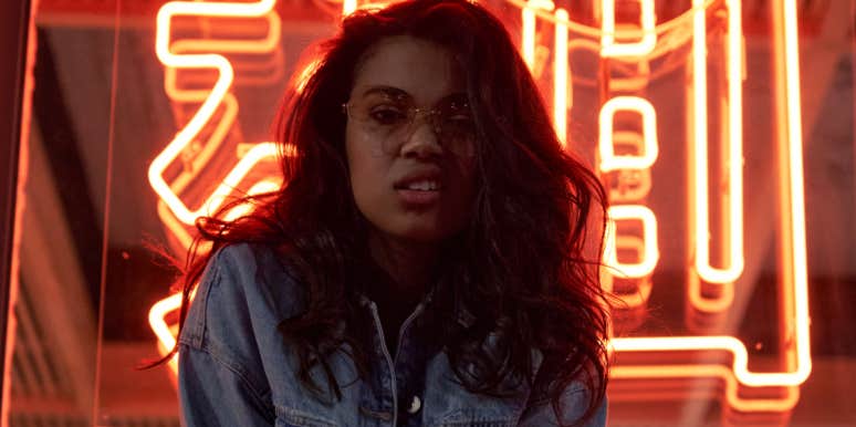 Why Modern Day Girls Don’t Need A Prince Charming woman posing in front of neon sign